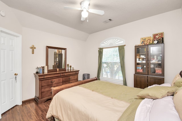 bedroom with dark hardwood / wood-style floors, a textured ceiling, and ceiling fan