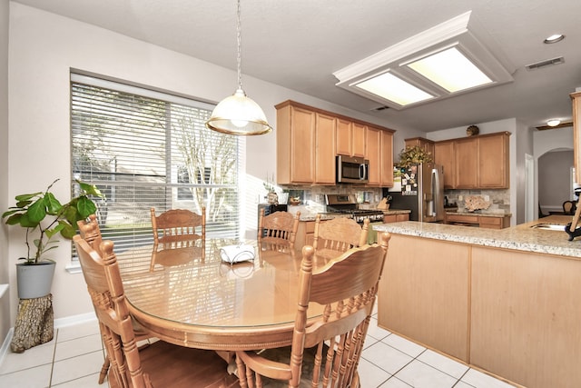 dining space featuring light tile patterned flooring and sink