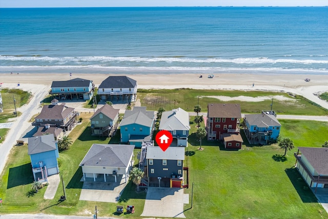 birds eye view of property featuring a water view and a beach view