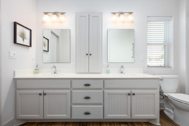 bathroom with hardwood / wood-style floors, vanity, and toilet