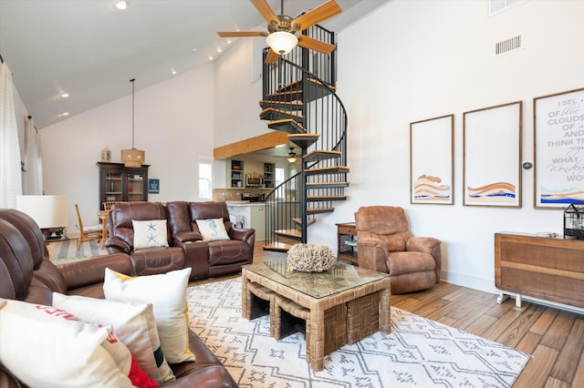 living room with high vaulted ceiling, ceiling fan, and light hardwood / wood-style floors