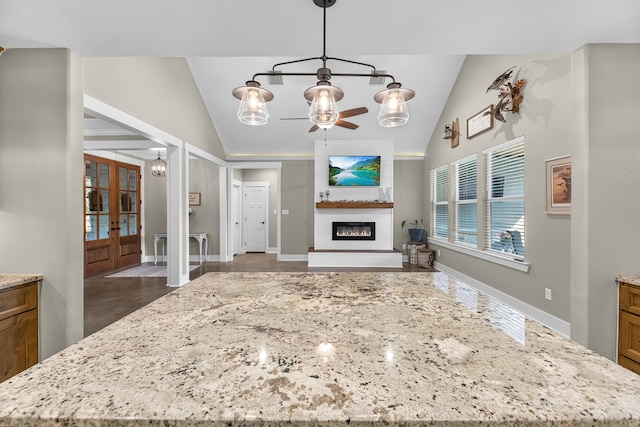 kitchen with french doors, decorative light fixtures, vaulted ceiling, and a kitchen island