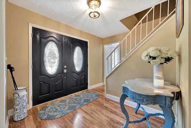 foyer entrance with a textured ceiling and hardwood / wood-style floors