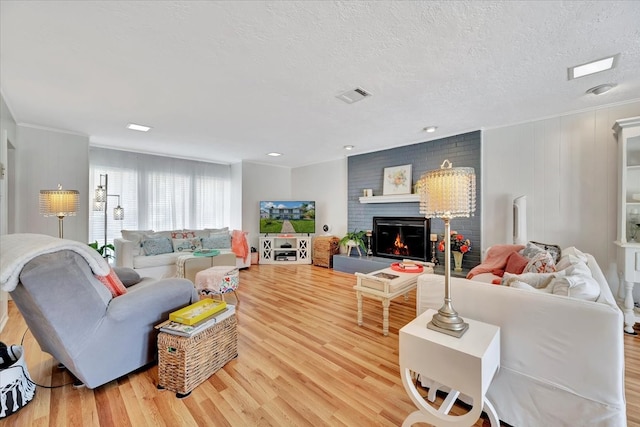 living room featuring a fireplace, hardwood / wood-style floors, and a textured ceiling