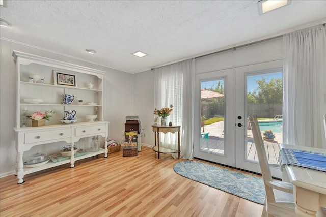 entryway featuring french doors, a textured ceiling, and light hardwood / wood-style floors