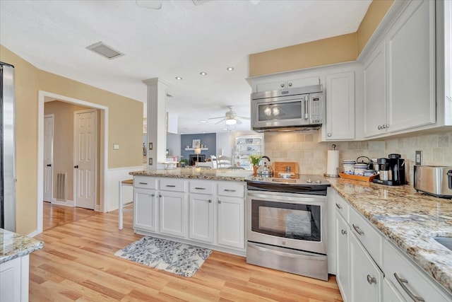 kitchen featuring stainless steel appliances, light hardwood / wood-style floors, and white cabinetry