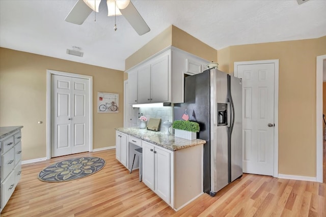 kitchen featuring light hardwood / wood-style flooring, decorative backsplash, white cabinets, and stainless steel refrigerator with ice dispenser