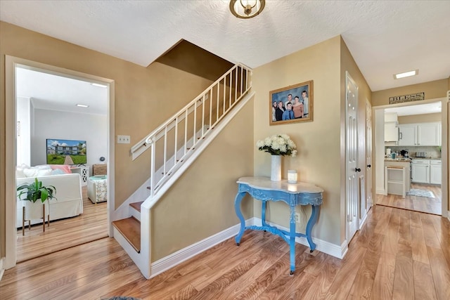 staircase featuring hardwood / wood-style floors and a textured ceiling