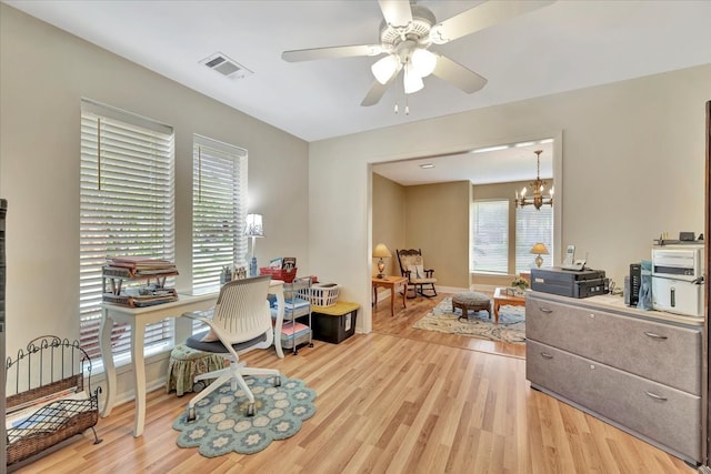 office area featuring ceiling fan with notable chandelier and light hardwood / wood-style floors