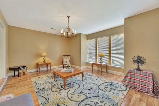 living area with an inviting chandelier and light hardwood / wood-style floors