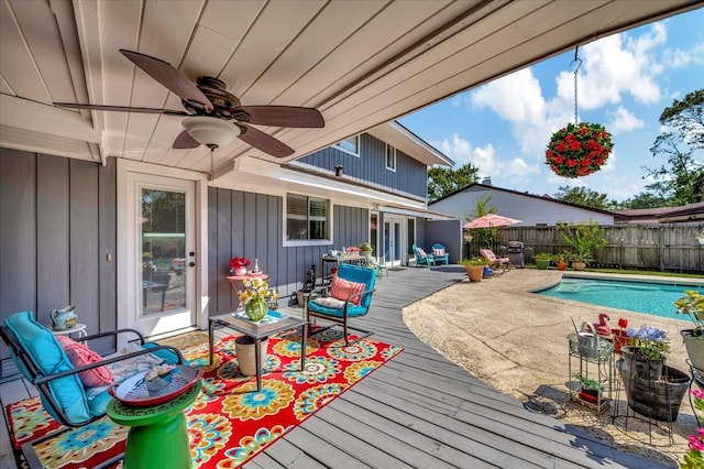 view of pool featuring ceiling fan and a wooden deck