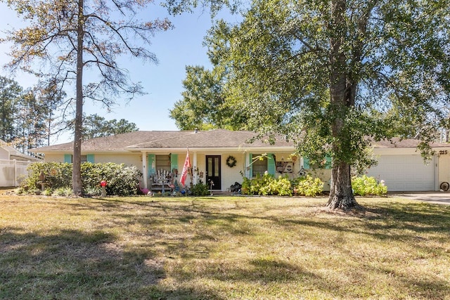 ranch-style home featuring covered porch, a garage, and a front yard