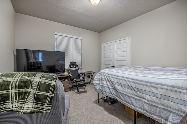 bedroom featuring light colored carpet and a textured ceiling