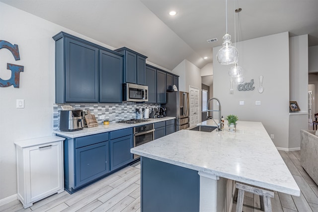 kitchen featuring pendant lighting, light hardwood / wood-style flooring, sink, lofted ceiling, and appliances with stainless steel finishes