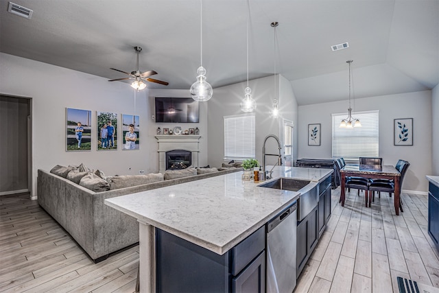 kitchen with dishwasher, a kitchen island with sink, plenty of natural light, and vaulted ceiling