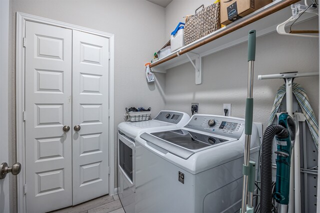 laundry room featuring light hardwood / wood-style flooring and washer and clothes dryer