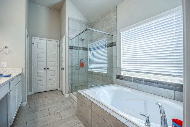 bathroom with lofted ceiling, plenty of natural light, vanity, and independent shower and bath