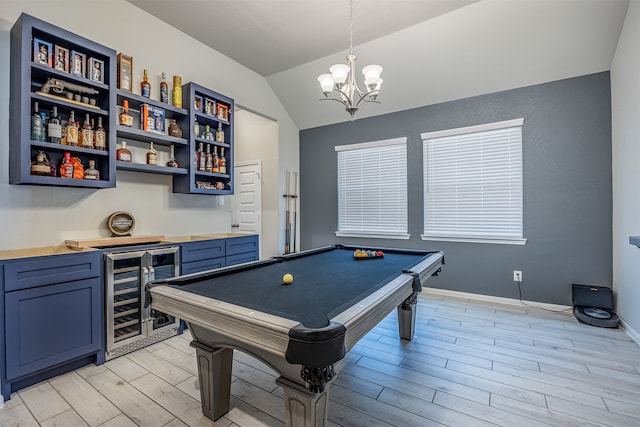 rec room featuring light wood-type flooring, bar area, beverage cooler, vaulted ceiling, and pool table