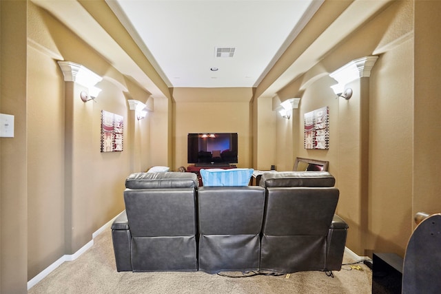 home theater room featuring ornate columns and light colored carpet