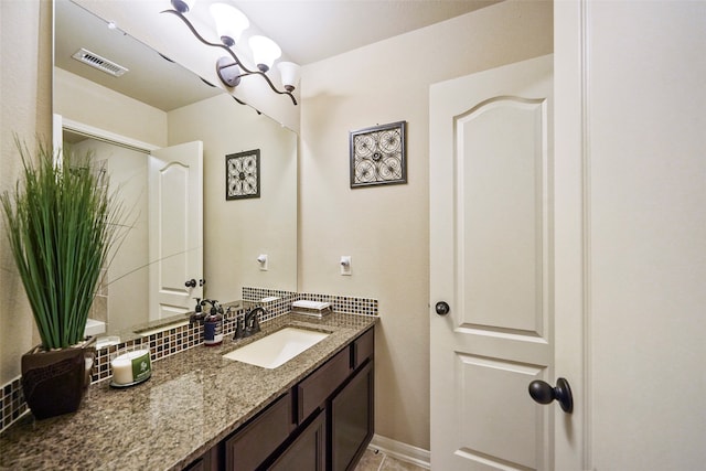 bathroom featuring tile patterned floors, backsplash, and vanity