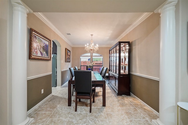 dining room featuring an inviting chandelier, crown molding, and ornate columns