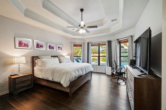 bedroom featuring dark hardwood / wood-style flooring, a tray ceiling, ceiling fan, and ornamental molding