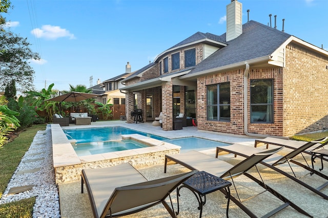 view of swimming pool featuring an in ground hot tub and a patio area