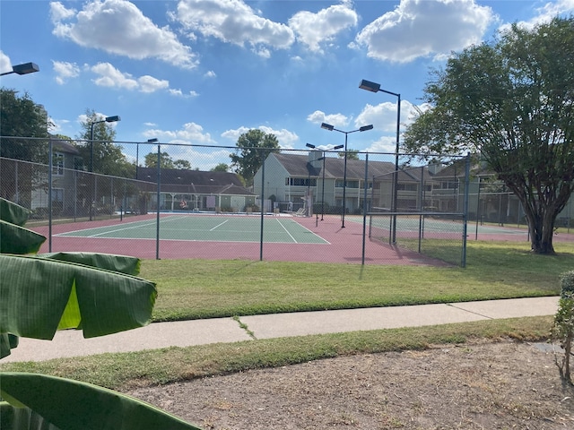 view of tennis court with a yard