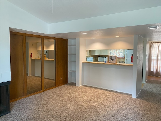 unfurnished living room featuring light carpet and lofted ceiling