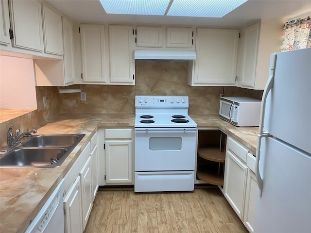 kitchen with white appliances, sink, backsplash, light hardwood / wood-style floors, and white cabinets