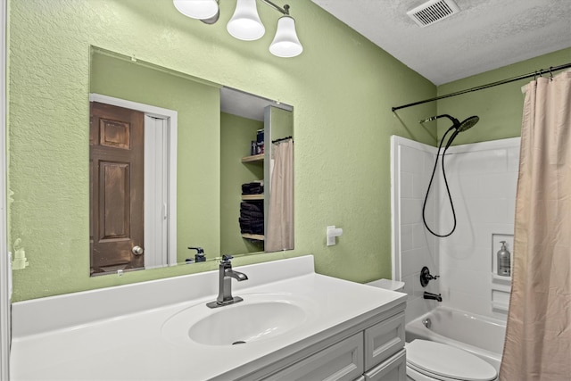 full bathroom with shower / bath combination with curtain, vanity, a textured ceiling, and toilet