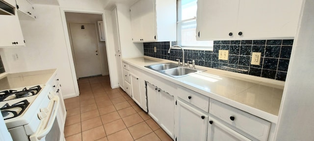 kitchen with light tile patterned floors, sink, decorative backsplash, and white cabinetry