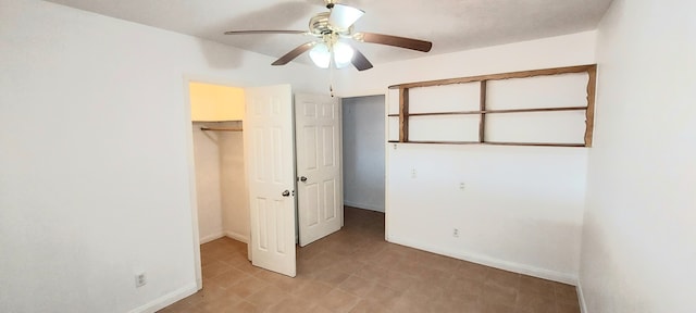 unfurnished bedroom featuring ceiling fan, a closet, and a walk in closet