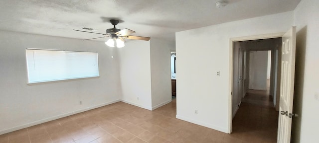 empty room with ceiling fan and a textured ceiling