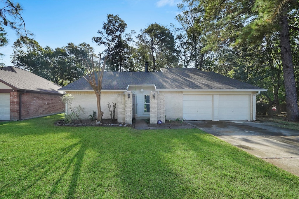 single story home featuring a garage and a front lawn