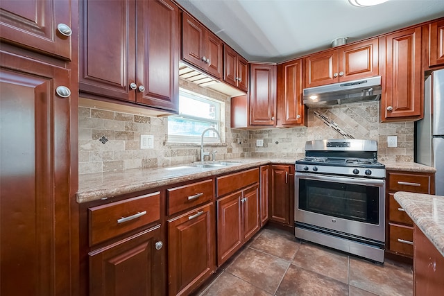 kitchen featuring stainless steel appliances, tasteful backsplash, sink, and light stone counters