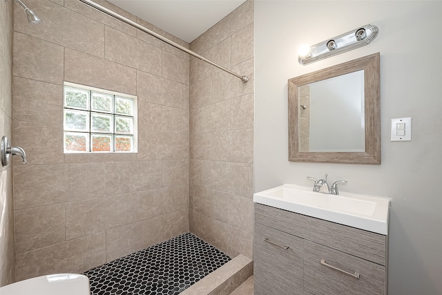 bathroom with vanity, a tile shower, and toilet