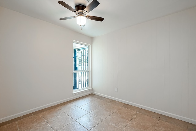 tiled spare room with ceiling fan