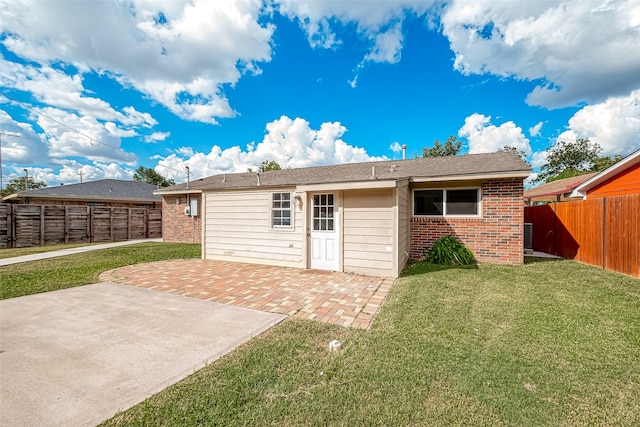 rear view of house with a yard and a patio area