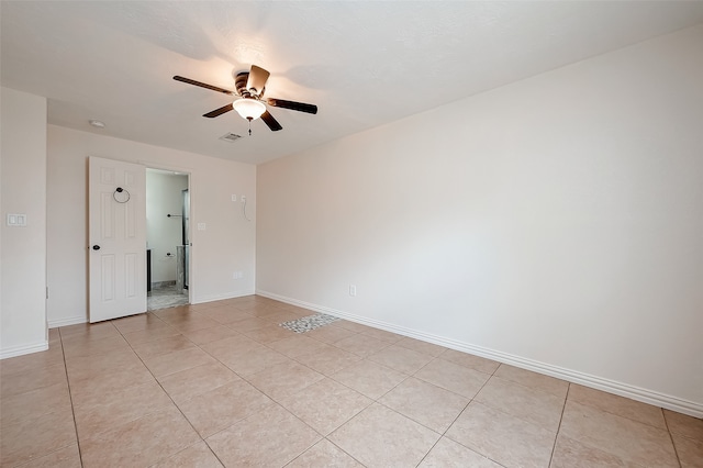 tiled spare room featuring ceiling fan