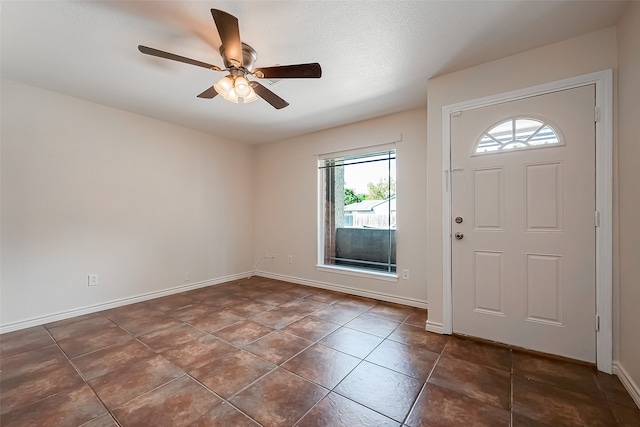 tiled foyer entrance featuring ceiling fan and a textured ceiling