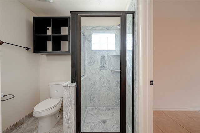 bathroom with tile patterned flooring, walk in shower, and toilet