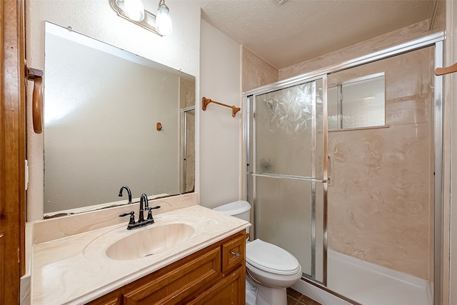 bathroom featuring a textured ceiling, a shower with shower door, vanity, and toilet