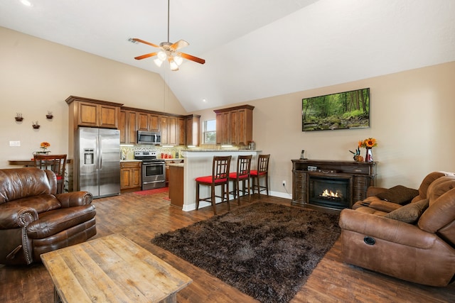 living room with ceiling fan, lofted ceiling, and dark hardwood / wood-style floors