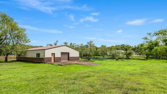 back of property featuring a garage, a yard, and an outdoor structure