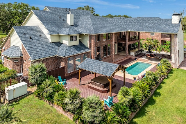 rear view of property with a pool with hot tub, a lawn, a patio area, and an outdoor hangout area