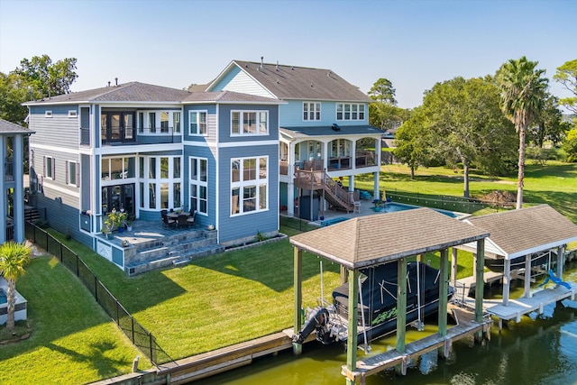 back of house featuring a lawn and a water view