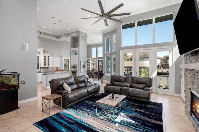 tiled living room with a fireplace, plenty of natural light, a towering ceiling, and crown molding