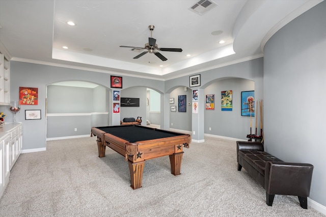 recreation room with light carpet, a tray ceiling, and crown molding