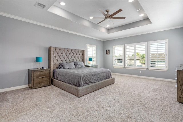 carpeted bedroom featuring a raised ceiling, ornamental molding, and ceiling fan